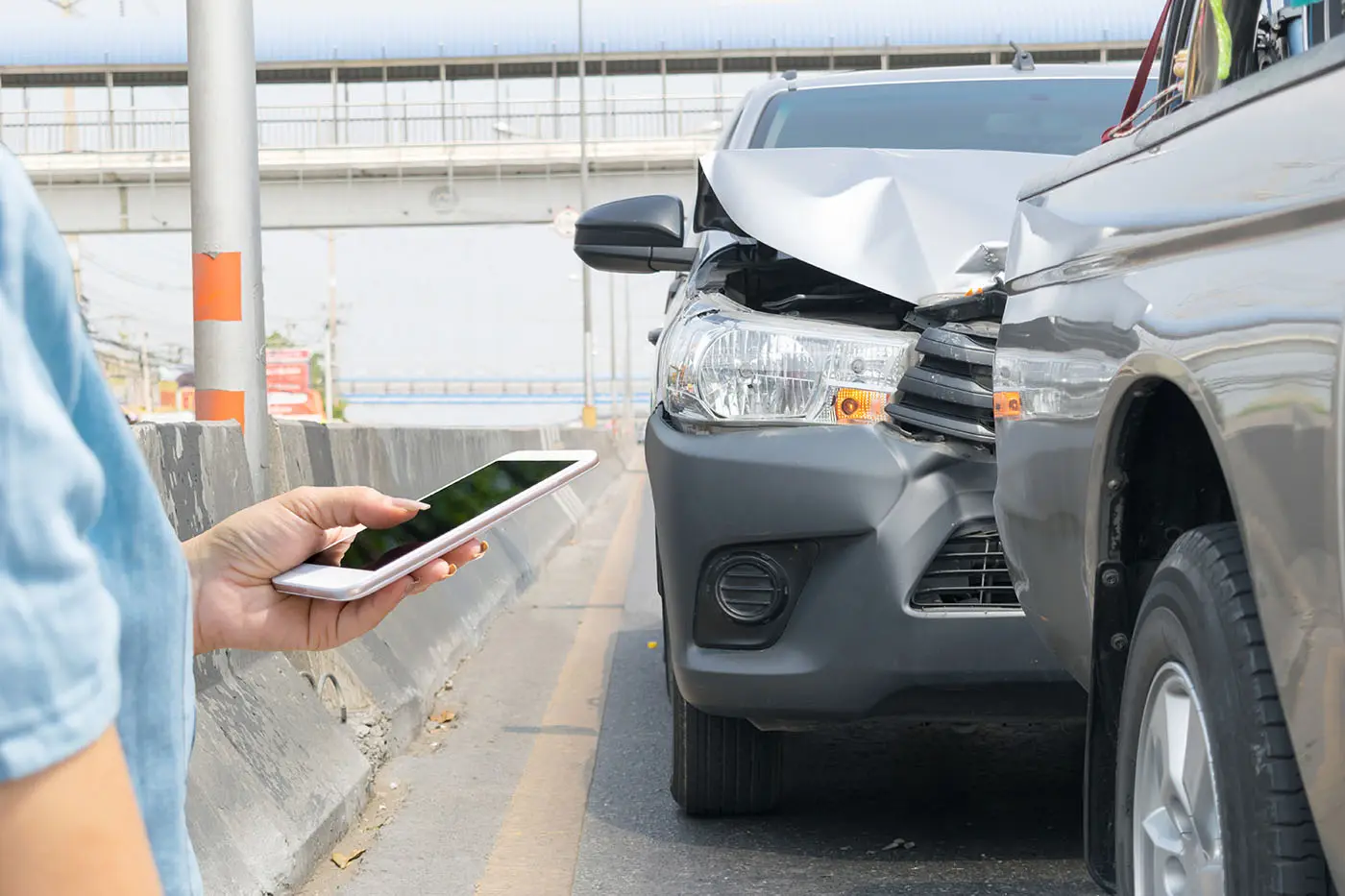 Choque entre dos vehículos tras un accidente de tránsito; una persona llama desde su celular